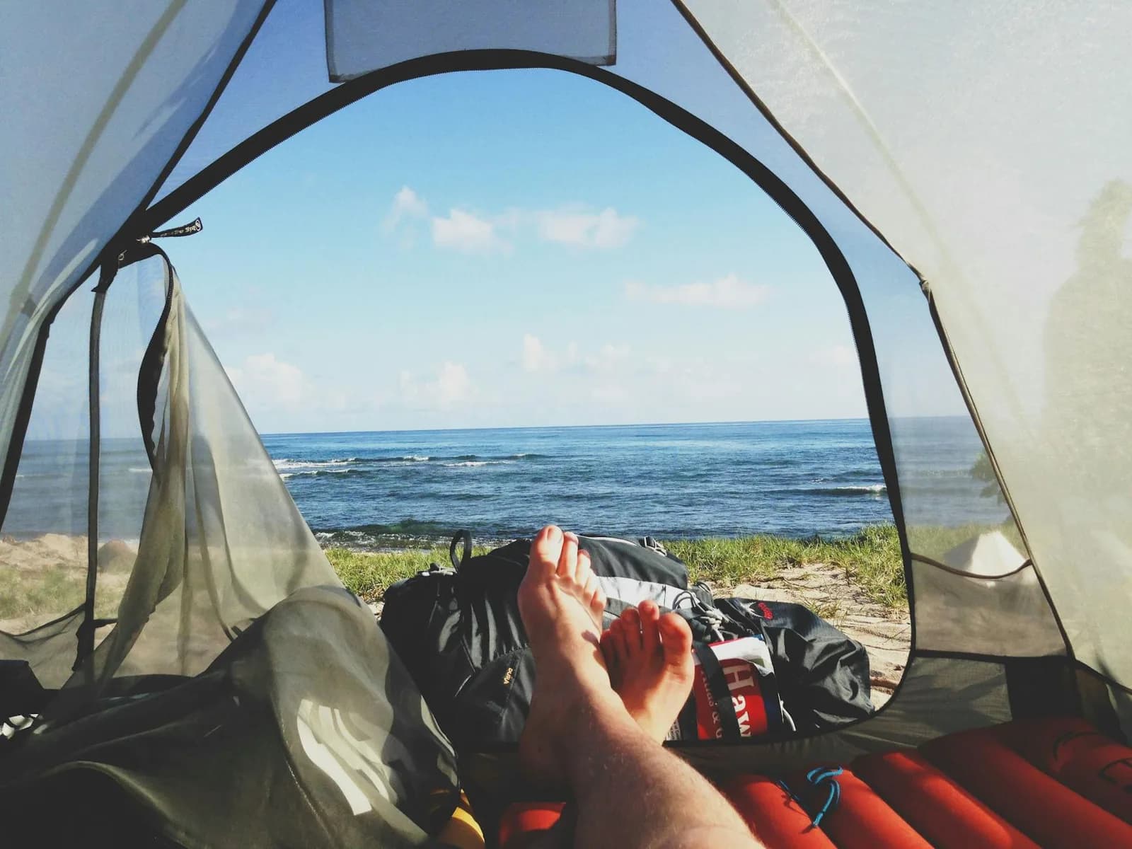 Matelas de bivouac gonflable posé sur l’herbe au petit matin