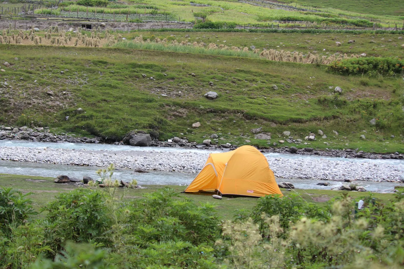Tente de bivouac installée sur un terrain naturel au coucher du soleil